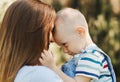 A young mother holds in her arms and hugs a little boy in the summer in nature Royalty Free Stock Photo