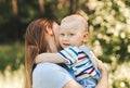 A young mother holds in her arms and hugs a little boy in the summer in nature Royalty Free Stock Photo