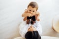 A young mother holds her cute little boy in her arms. A charming woman is playing with her sweet baby. Mom and son have fun at Royalty Free Stock Photo