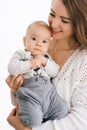 A young mother holds her little son in her arms and smiles on a white background Royalty Free Stock Photo