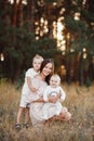 Young mother hugging her two little sons. Family holiday in the park. Portrait mom with children together on nature. Mum Royalty Free Stock Photo