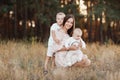 Young mother hugging her two little sons. Family holiday in the park. Portrait mom with children together on nature. Mum Royalty Free Stock Photo