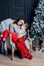 Young mother hugs daughter in pajamas holding her in her arms. The girl put her head on her mother's lap. Royalty Free Stock Photo