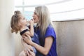 A young mother hugs and kisses her baby in the afternoon on the terrace. Happy mother playing with her child.Mom and son. Royalty Free Stock Photo