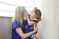 A young mother hugs and kisses her baby in the afternoon on the terrace. Happy mother playing with her child. Royalty Free Stock Photo