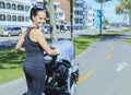Young mother jogging with a baby buggy Royalty Free Stock Photo