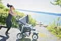 A Young mother jogging with a baby buggy Royalty Free Stock Photo