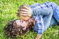 Young mother and kid relaxing outdoor laying down on her on grass in park garden. mom and son having fun chilling outside in the Royalty Free Stock Photo