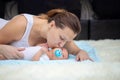 A young mother kisses her newborn baby. Baby sucks pacifier