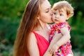 Young mother kissing baby daughter in park Royalty Free Stock Photo