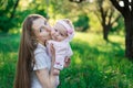Young mother kissing baby on nature background. Walk in Park with baby Royalty Free Stock Photo