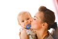 Young mother kissing baby with soother Royalty Free Stock Photo