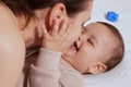 Young mother, kissing her baby boy at home. Family concept. Closeup portrait of loving mother young woman kissing little Royalty Free Stock Photo