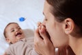 Young mother, kissing her baby boy at home. Family concept. Closeup portrait of loving mother young woman kissing little Royalty Free Stock Photo