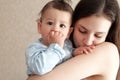 Young mother, kissing her baby boy at home. Family concept. Closeup portrait of loving mother young woman kissing little Royalty Free Stock Photo