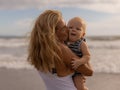 Young mother kissing her baby son. Mum with infant spending time on the beach. Summer vacation in Asia. Family concept. Happy Royalty Free Stock Photo