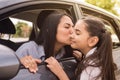 Young mother kissing her daughter on the cheek before entering school from the car Royalty Free Stock Photo