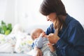 Young mother, kissing her newborn baby boy at home Royalty Free Stock Photo