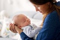 Young mother, kissing her newborn baby boy at home Royalty Free Stock Photo