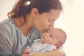 Young mother, kissing her newborn baby boy at home Royalty Free Stock Photo
