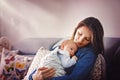 Young mother, kissing her newborn baby boy at home Royalty Free Stock Photo