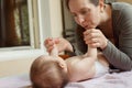 Young mother kissing the tiny feet of her baby Royalty Free Stock Photo