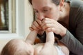 Young mother kissing the tiny feet of her baby Royalty Free Stock Photo