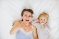 Young mother laying with baby in bed Royalty Free Stock Photo