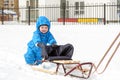 Young mother and little boy enjoying sleigh ride. Child sledding. Toddler kid riding sledge. Children play outdoors in snow. Kids Royalty Free Stock Photo