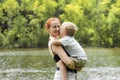 Young mother and little child kid boy son in park.Happy family playing,having fun,holding on hands,hugging in nature against trees Royalty Free Stock Photo