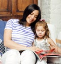 Young mother with little cute daughter on white, happy smiling family inside isolated adorable, lifestyle modern people Royalty Free Stock Photo