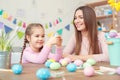 Mother and daughter easter celebration together at home sitting looking at egg smiling Royalty Free Stock Photo