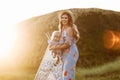 Young mother with little daughter are having fun in the field on sunset. Portrait mom with child together on nature on summer day Royalty Free Stock Photo