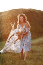 Young mother with little daughter are having fun in the field on sunset. Portrait mom with child together on nature on summer day Royalty Free Stock Photo