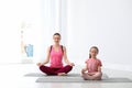 Young mother with little daughter practicing yoga