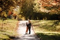 Young mother and little daughter sitting on fathers shoulders are walking outdoors at autumn park. Dad, mom and child Royalty Free Stock Photo