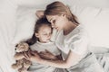 Young Mother and Little Doughter Together in Bed Royalty Free Stock Photo