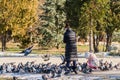 A young mother with a little girl feeds pigeons in the park Royalty Free Stock Photo