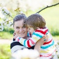 Young mother and little kid boy having fun in blooming garden Royalty Free Stock Photo