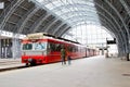 Young mother and little kid walk through the Bergen train station platforms with typical red Voss train on background, Bergen. Royalty Free Stock Photo