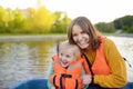 Young mother and little son boating on a river or pond at sunny summer day. Quality family time together on nature