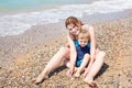 Young mother and little son having fun on beach Royalty Free Stock Photo