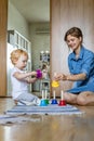 Young mother and little toddler playing childish colorful hand bells music sound at home