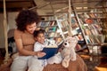 A young mother loves reading a book to her little daughter while sitting on the swing at home together. Family, together, leisure Royalty Free Stock Photo