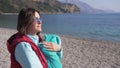 Young mother lulls her son on the beach on a sunny spring day