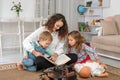 Young mother or nanny with small children, a boy and a girl, sit Royalty Free Stock Photo