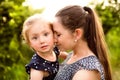 Young mother in nature holding little daughter in the arms. Royalty Free Stock Photo