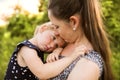 Young mother in nature holding little daughter in the arms. Royalty Free Stock Photo