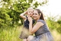 Young mother in nature holding little daughter in the arms. Royalty Free Stock Photo