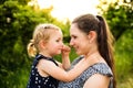 Young mother in nature holding little daughter in the arms. Royalty Free Stock Photo